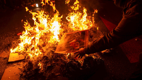 Varios manifestantes queman fotos del rey Felipe durante la protesta llevada a cabo en la avenida Diagonal de Barcelona, en protesta por la visita del monarca a la capital catalana. EFE/ Enric Fontcuberta