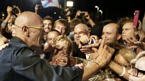 El cabeza de lista de Junts pel Si, Raul Romeva, saluda a los simpatizantes de su formación que esperan los resultados de las elecciones catalanas frente al cuartel general ubicado frente al Mercat del Born./ EFE