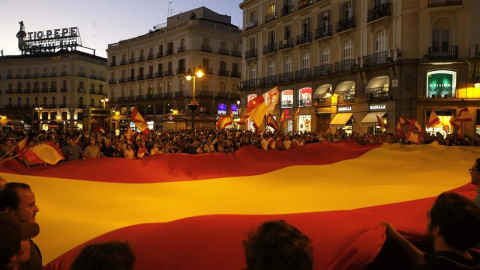 Un grupo de personas desplegó una gran bandera de España en la Puerta del Sol de Madrid en una concentración convocada a través de las Redes Sociales en contra de la independencia de Catalunya./ EFE