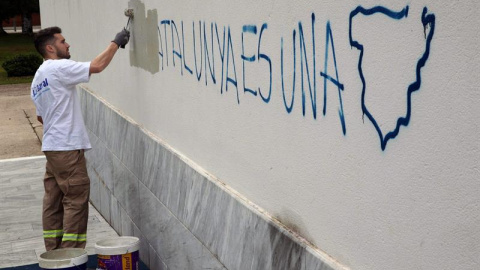 Un operario de la brigada de limpieza borran una pintada en el colegio electoral situado en el Centro Cultural Mira-sol de San Cugat donde ha votado el cabeza de lista de Junts pel Sí, Raül Romeva. /EFE