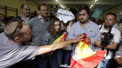 Un a persona trata de arrebatar una bandera a un miembro de VOX en el colegio donde acudió a votar en las elecciones que se celebran en Catalunya, el presidente de la Generalitat y número cuatro en las listas de Junt pel Si, Artur Mas, EFE/