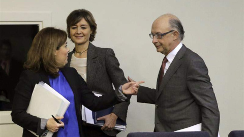 El ministro de Hacienda, Cristóbal Montoro, la vicepresidenta del Gobierno, Soraya Sáenz de Santamaría (i), y la ministra de Agricultura, Alimentación y Medio Ambiente, Isabel García Tejerina (c), al inicio de la rueda de prensa que han ofr