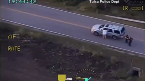 Imagen del video de la Policía de Tlsa (Oklahoma) en la que se ve a  Terence Crutcher junto a su vehículo apuntado por varios agentes después de tener una avería en la carretera. REUTERS