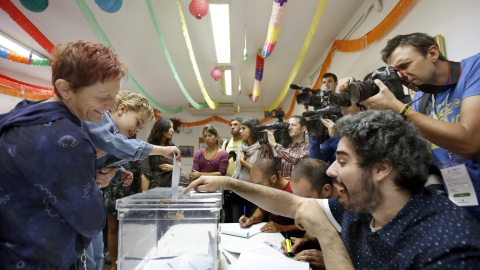 Un niño, en brazos de su madre, deposita el voto en la urna en una mesa del Centro Cívico El Turó de Sant Vicenç dels Hors (Barcelona), en las elecciones autonómicas del 27-S. EFE/Andreu Dalmau