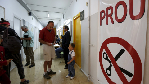 Un hombre se prepara a salir después de haber votado con su hijo en un colegio electoral en Barcelona, en las autonómicas del 27-S. REUTERS/ Gustau Nacarino