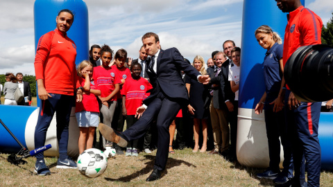 El presidente francés Emanuel Macron golpea a un balón en su visita a un centro de recreo para menores en la localidad de Moisson. REUTERS/Philippe Wojazer