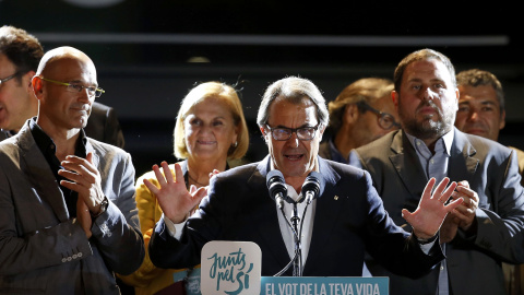 Artur Mas, entre Raul Romeva y Oruiol Junqueras, se dirige a los seguidores de Junts Pel Si, en la noche electoral del 27-S. REUTERS/Sergio Perez