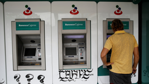 Un hombre utiliza un cajero automático en una sucursal del banco Banesco, en Caracas. REUTERS/Carlos Garcia Rawlins