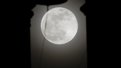 La superluna, tras el campanario de la iglesia de San Nicolás, en Cali (Colombia). AFP/LUIS ROBAYO