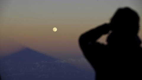 Un hombre contempla como la sombra del volcán Teide, en la isla de Tenerife, se alinea con la superluna. Durante la próxima madrugada se producirá un eclipse total de Luna. EFE/Ramón de la Rocha