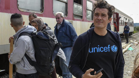 El embajador de buena voluntad de Unicef y actor Orlando Bloom observa a los refugiados que suben a bordo de un tren con destino a la frontera serbia, en Gevgelija (Macedonia). EFE/Georgi Licovski