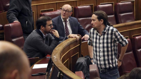 El secretario general de Podemos, Pablo Iglesias (d). conversa con el líder de IU, Alberto Garzón, durante un pleno del Congreso. (J.J. GUILLÉN | EFE)