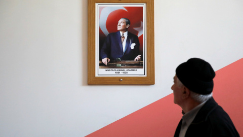 Un hombre pasa junto a un retrato del fundador del Estado turco, Mustafa Kemal Ataturk, en un colegio electoral en Estambul, en la jornada de elecciones locales. REUTERS/Kemal Aslan