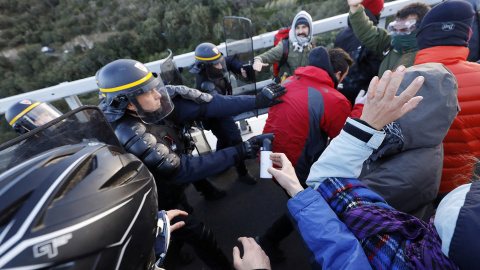 Miembros del grupo de protesta catalán Tsunami demócrata se enfrentan con agentes de policía franceses en la autopista AP-7 en el lado francés de la frontera franco-española. REUTERS / Rafael Marchante