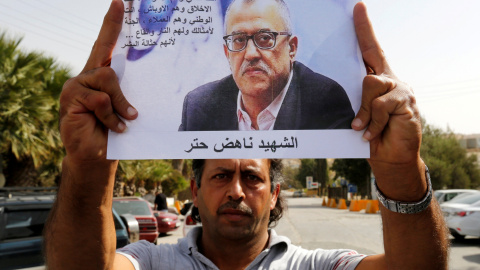 Un amigo de Nahed Hattar sostiene una fotografía del escritor jordano, asesinado por un islamisa radical. REUTERS/Muhammad Hamed