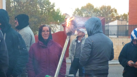 Una mujer calentándose en el fuego encendido durante la paralización del desahucio de Diego Catriel en Guadalajara. / María Duarte