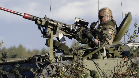 A Danish Army soldier takes off her helmet during a break in the "Silver Arrow 2015" NATO military exercise, at a training field near Adazi, Latvia, September 27, 2015. Approximately 2,400 personnel from six nations are participating, said 