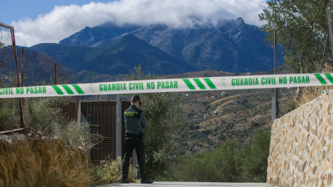 Un agente de la Guardia Civil custodia el acceso a la casa en la que se encontró el cadáver de una mujer con aparentes signos de violencia. EFE