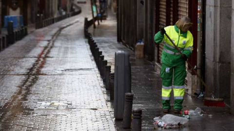 Una trabajadora de los Servicios de Limpieza de Madrid recoge basura. EFE