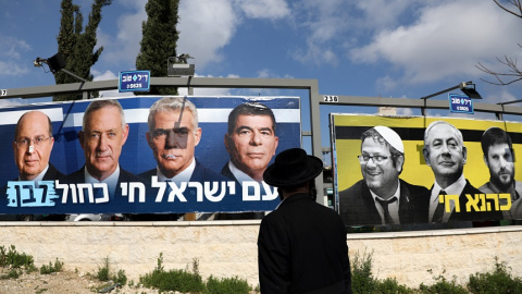 27/03/2019 - Un judío ortodoxo observa los carteles de la campaña electoral israelí. / REUTERS - AMMAR AWAD