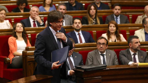 El presidente catalán, Carles Puigdemont, se dirige a la tribuna para su intervención en el debate de la cuestión de confianza, la primera que vive el Parlament desde que fue restablecido y para la que ya cuenta con el aval de la CUP, en la