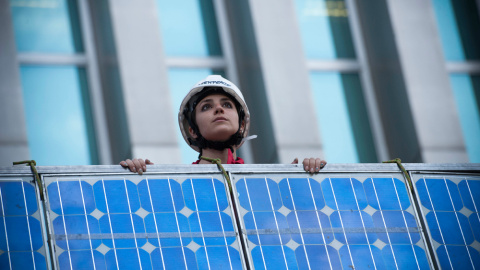 Activistas de Greenpeace subiendo una placa solar por la fachada del Ministerio. GREENPEACE