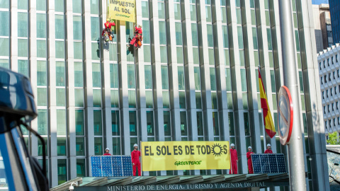 Activistas de Greenpeace subiendo una placa solar por la fachada del Ministerio. GREENPEACE