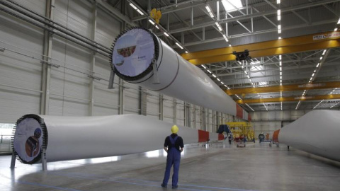 Un trabajador mira un ala que está siendo levantada mecánicamente en la fábrica de turbinas eólicas de Nordex en Rostock. REUTERS / Tobias Schwarz