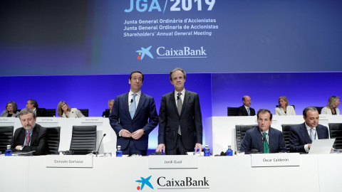 El presidente de CaixaBank, Jordi Gual, acompañado por el consejero delegado, Gonzalo Cortázar, al inicio de la junta general ordinaria de accionistas en Valencia. EFE/ Kai Försterling