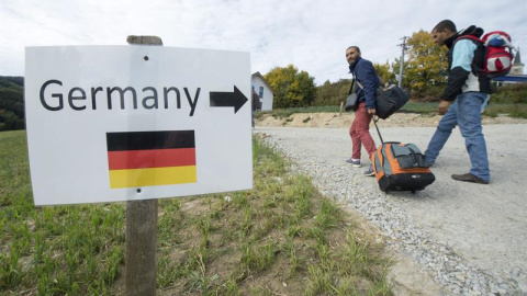 Cartel que indica a los refugiados sirios por dónde se va a Alemania, en la localidad austriaca de Julbach. / EFE