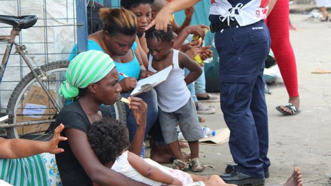 Mujeres y niños reposan en una frontera - EFE