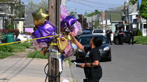  Una mujer deja un globo en un monumento improvisado cerca de una tienda Tops Grocery en Buffalo, Nueva York, el 15 de mayo de 2022, el día después de que un hombre armado matara a tiros a 10 personas. Los residentes afligidos de la ciudad 