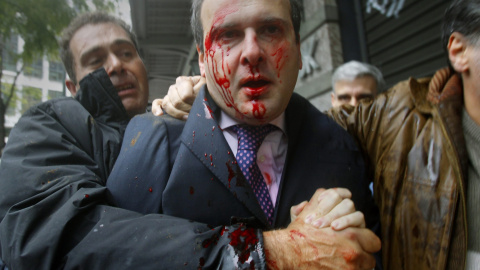 El ex ministro conservador Kostis Hatzidakis cubierto de sangre después de un incidente con un grupo de manifestantes que lo atacaron con piedras y palos, gritando "¡Ladrones! ¡La culpa es vuestra!" (15 de diciembre 2010). REUTERS / Yannis 