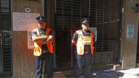 Dos policías argentinos custodian la entrada al domicilio de Nisman, por delante de un cartel colocado por un ciudadano en el que se lee "Yo soy Nisman". REUTERS