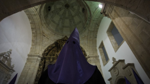 A hooded penitent of the "Numeraria del Rosario" brotherhood waits for the start of the Santo Entierro procession at the San Domingos de Bonaval church, during Holy Week in Santiago de Compostela, northwestern Spain, on March 25, 2016. Chri