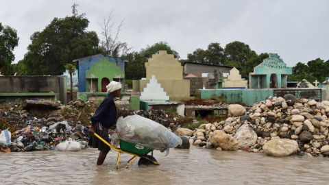 Una mujer empuja una carretilla en una calle inundada de Puerto Príncipe, Haití. - AFP