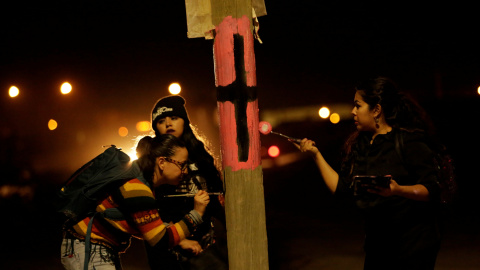 Unas activistas pintan una cruz negra en una farola para recordar a las víctimas de violencia machista con motivo del Día Internacional de la Mujer en Ciudad Juárez, Mexico. REUTERS/Jose Luis Gonzalez