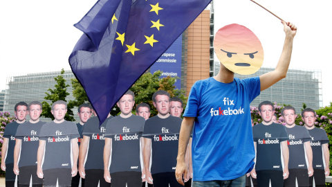 Un manifestante sostiene una bandera de la Unión Europea junto a efigies de cartón que representan al fuundador de Facebook, Mark Zuckerberg, durante una concentración antes de una reunión entre el empresario de Internet y los líderes del P