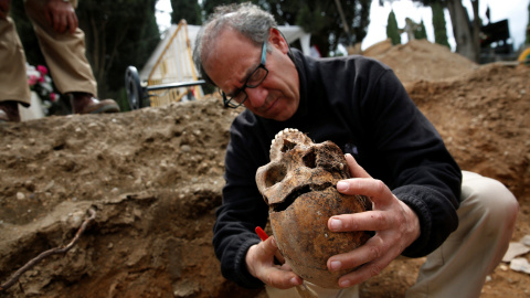 Julio del Olmo, arqueólogo de la ARMH-Valladolid examina el cráneo exhumado en una fosa con alrededor de 200 republicanos fusilados por el bando franquista durante la Guerra Civil, en el cementerio de El Carmen de ValladoliD.- REUTERS -JUAN