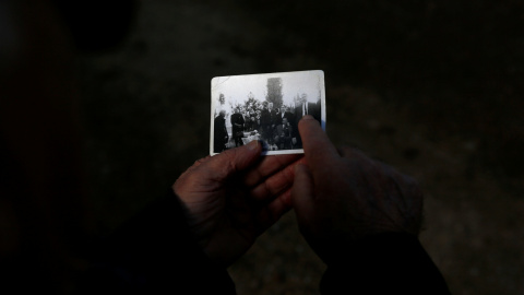 Abilio Pérez sostiene una fotografía de familia cerca de la fosa común donde se cree que su suegro fue arrojado después de haber sido asesinado por las fuerzas de Franco durante la Guerra Civil, en el cementerio de El Carmen en Valladolid.-