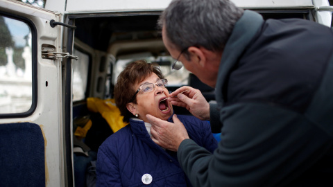 Fernando Serrulla, antropólogo forense de la Sociedad de Ciencias Aranzadi, toma una muestra de saliva de Julia Merino para una prueba de ADN durante la exhumación de la una de las tres fosas comunes que contienen en total los restos de alr