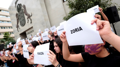 En Las Palmas de Gran Canaria jóvenes de dos centros de enseñanza de secundaria han mostrado hojas con los nombres de las asesinadas por la violencia de género durante el acto institucional del Gobierno de Canarias./ Ángel Medina G. (EFE)