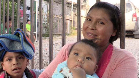 La mexicana Silvia Cayetana y sus hijos hacen fila en la calle para recibir cena en uno de los albergues situados en Nogales (México). / Aitana Vargas