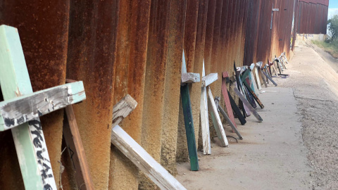 Apoyadas sobre el muro fronterizo en Nogales (México) hay decenas de cruces de madera en honor a los migrantes que perecieron tratando de alcanzar EE.UU. con vida. / Aitana Vargas