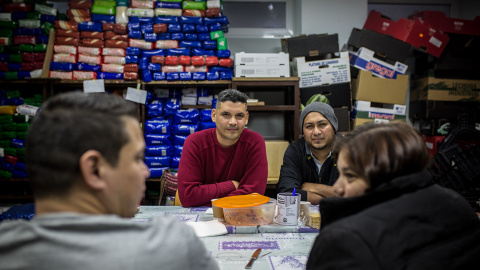 Jonatan Urdaneta y Alexander Orellana, solicitantes de asilo venezolano y salvadoreno, durante su comida de despedida con Mauricio Castaneda y Aida Burgo, procedentes de El Salvador, en el local de la Red Solidaria de Acogida en Puerta del 