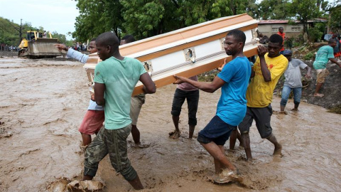 Varios hombres cargan un ataúd e intentan cruzar el río La Digue, en Petit Goave (Haití). - EFE