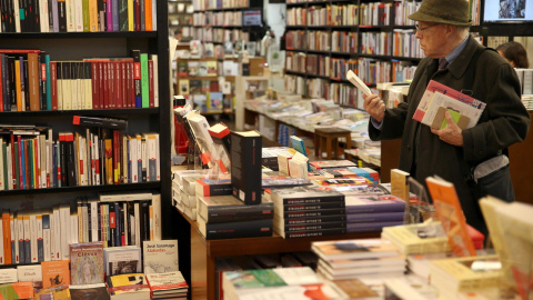 Una hombre hojea unos libros hoy en la librería la Central de Barcelona, en el Día de las Librerías.- EFE