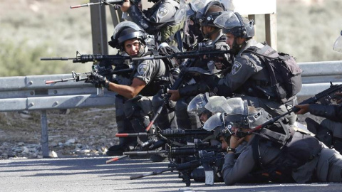 Soldados israelíes toman posiciones frente a manifestantes palestinos durante los enfrentamientos en el puesto de control de Howara, cerca de Nablus, Cisjordania.-  EFE / EPA / ALAA Badarneh