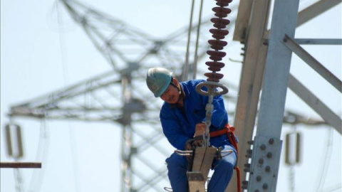 Un trabajador instala nuevas líneas de alto voltaje en una torre de electricidad. EFE/Archivo