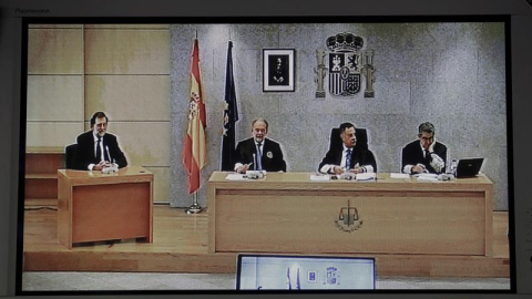 Imagen del monitor de la sala de prensa de la Audiencia Nacional de San Fernando de Henares del presidente del Gobierno, Mariano Rajoy (i). /EFE